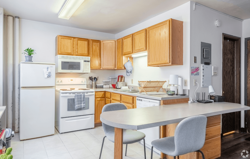 A kitchen with wooden cabinets and white appliances.