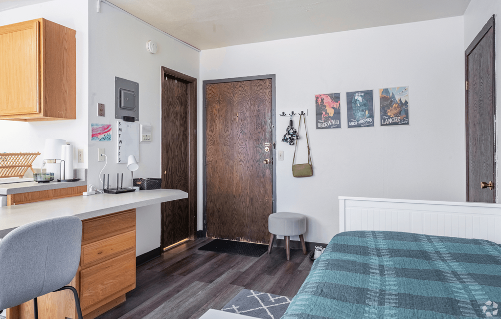 A kitchen with a white fridge and a white chair.