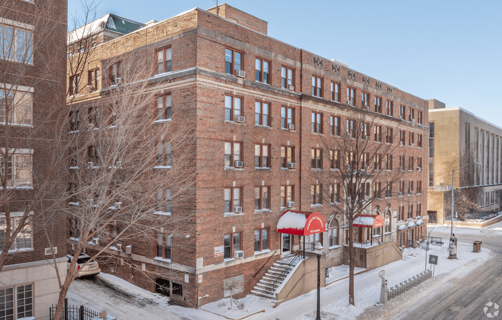 A large red and white building with a snow covered ground.