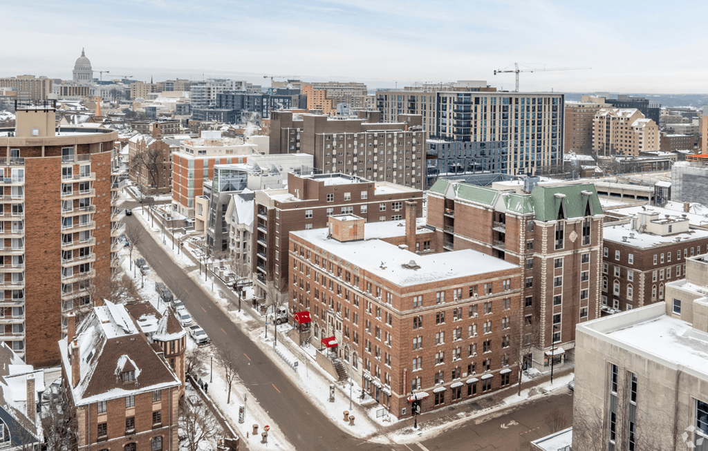 A city street with buildings on either side and snow on the ground.