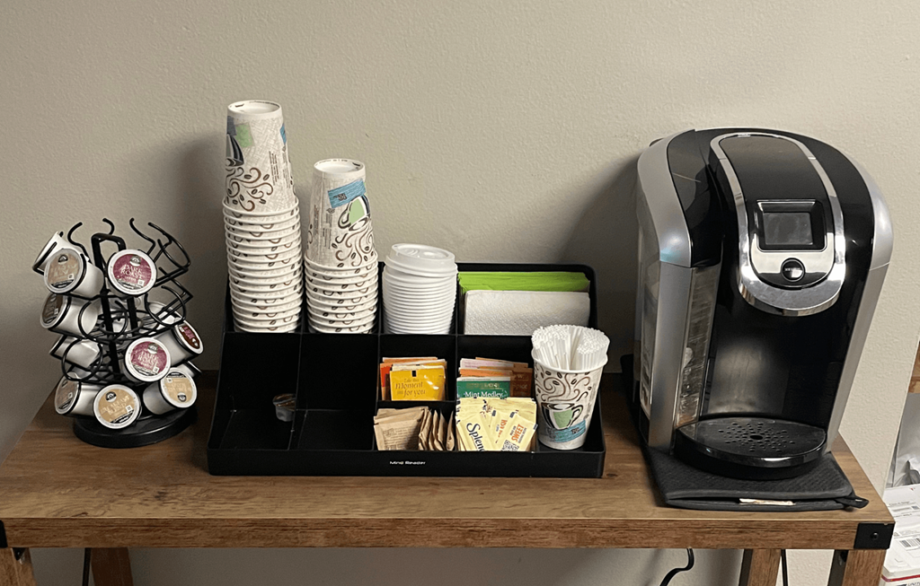 A coffee machine and a tray with coffee cups and a coffee grinder.