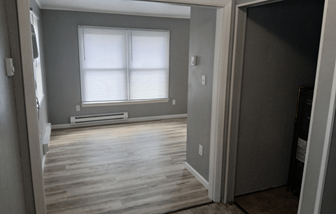 A room with a window and wooden floors.