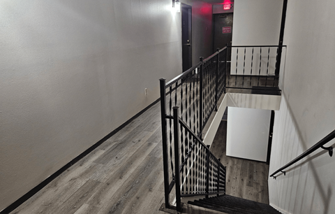 A staircase with a black railing and wooden steps.