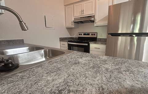 A kitchen with a stove, oven, and refrigerator.