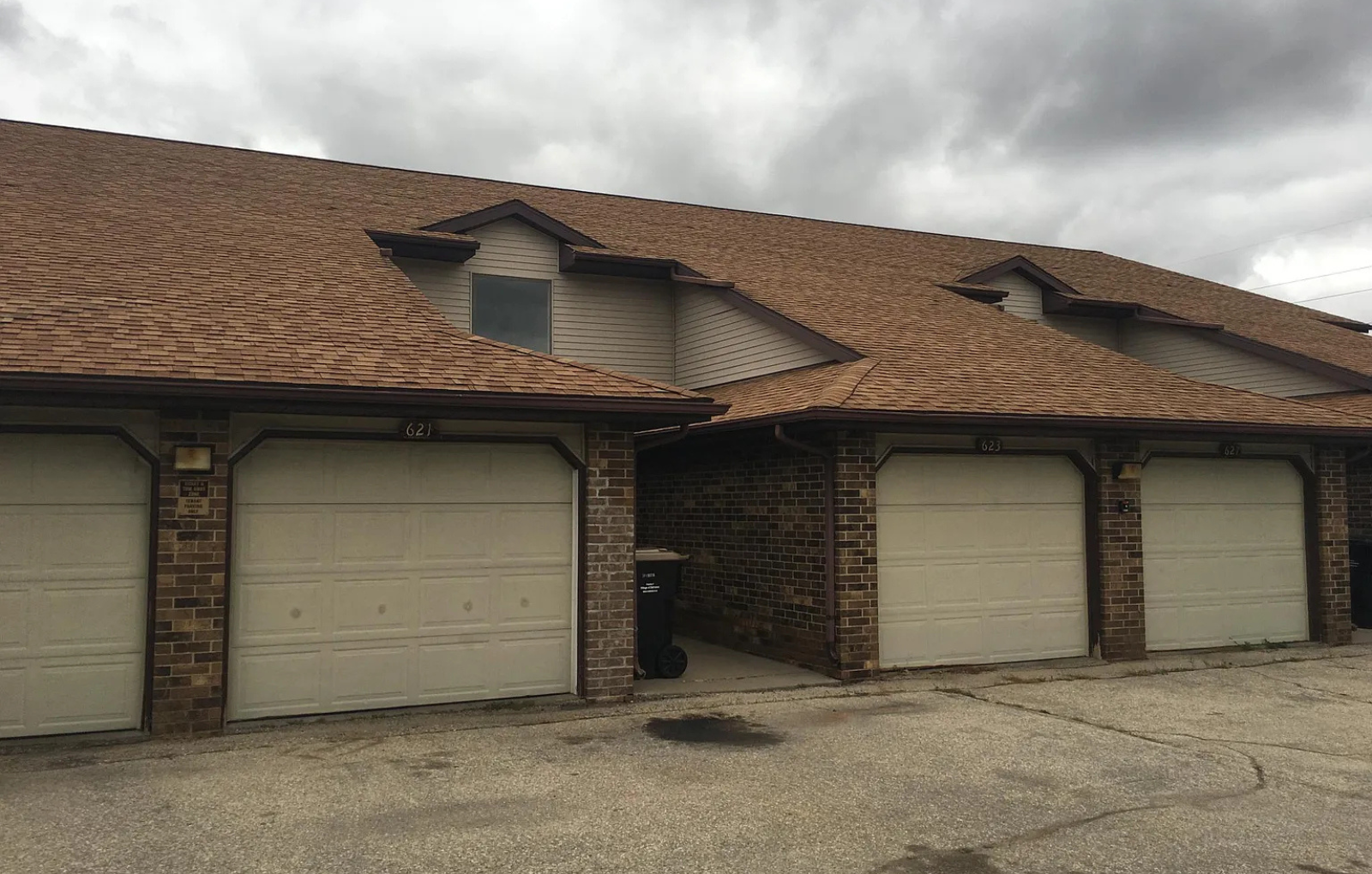 A house with a brown roof and three garage doors.