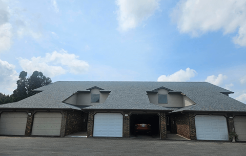 A house with a garage and a brick wall.