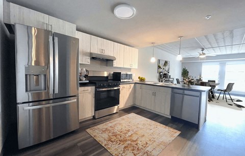 a large kitchen with stainless steel appliances and white cabinets