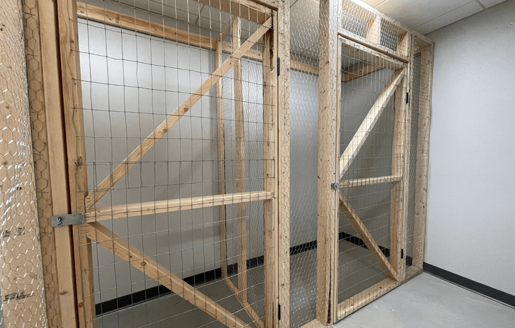 a room with a wooden door and a white tiled wall