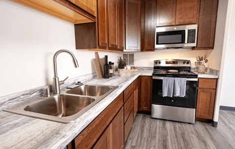 A modern kitchen with a stainless steel sink and stove.