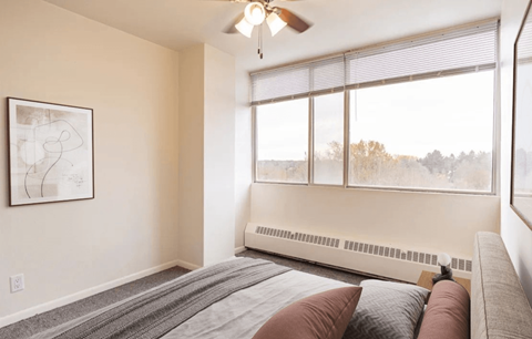 A bedroom with a large bed and a ceiling fan.