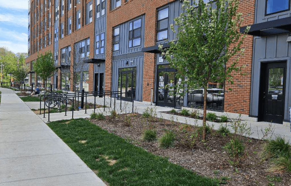 a sidewalk in front of a brick building