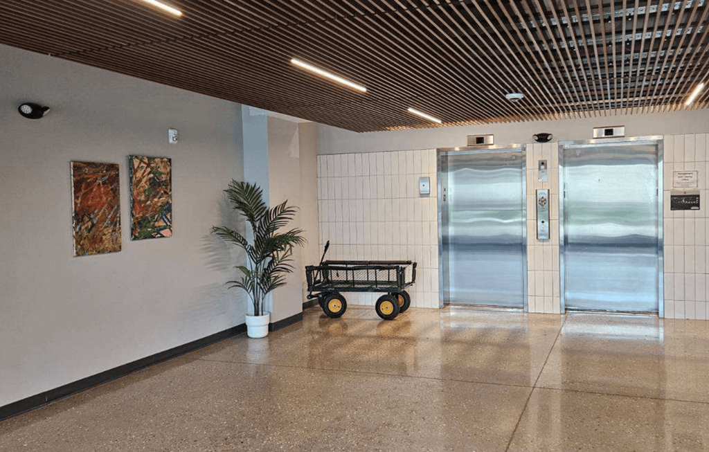 a lobby with a cart and a plant in front of a door