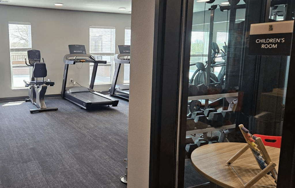 a gym with exercise equipment and a table in a room
