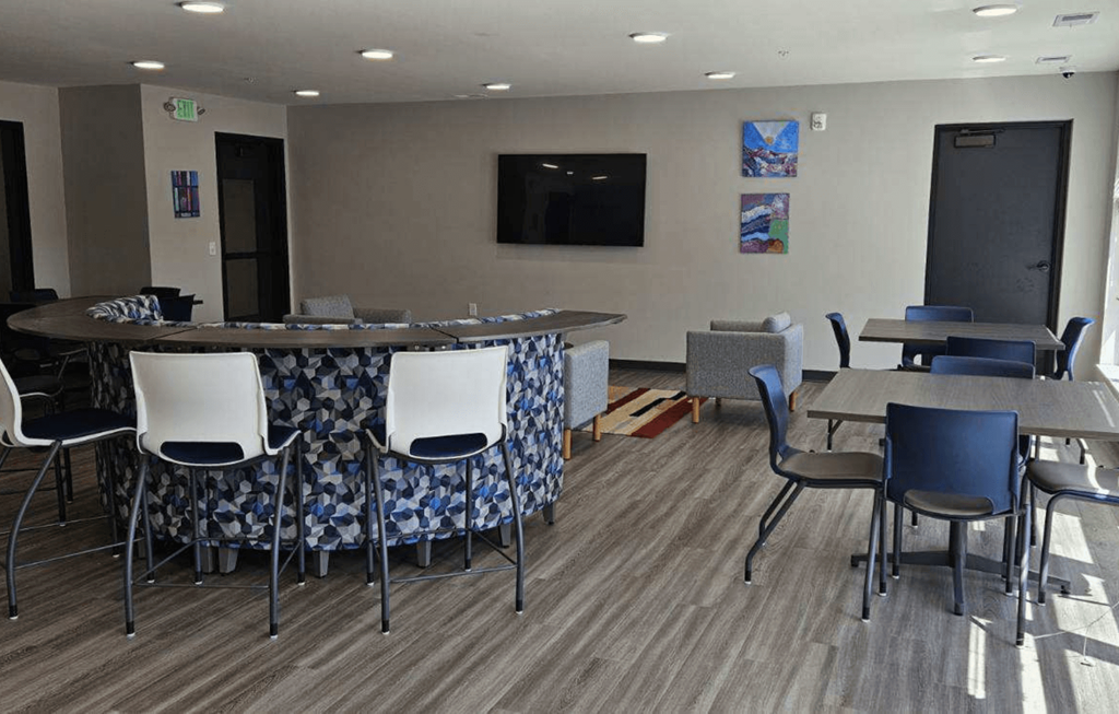 a room with a bar and chairs and tables