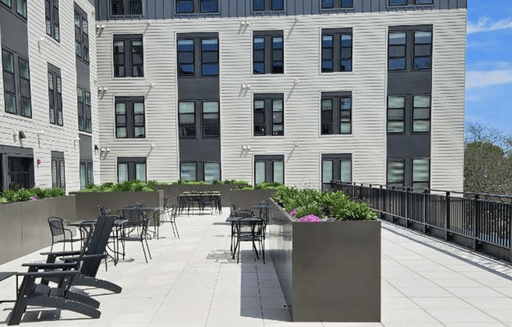 a patio with tables and chairs in front of a building