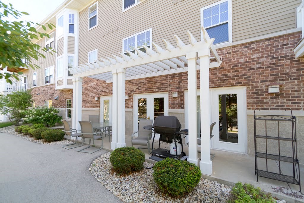 a patio with a pergola in front of a building