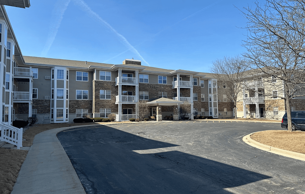 Apartment complex with a white picket fence and a gazebo.