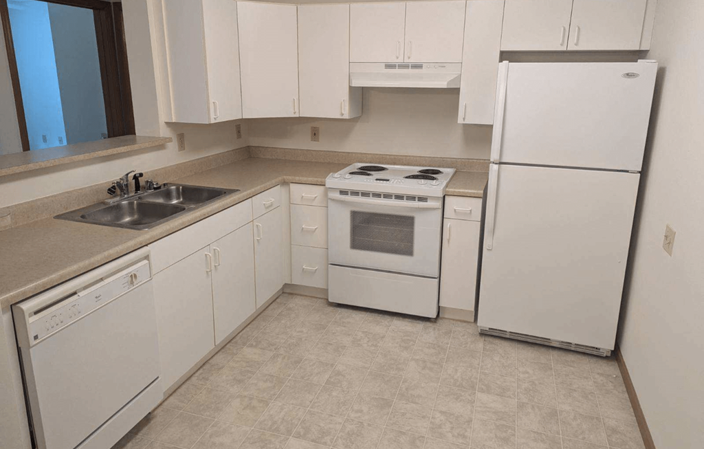 a white kitchen with white appliances and white cabinets