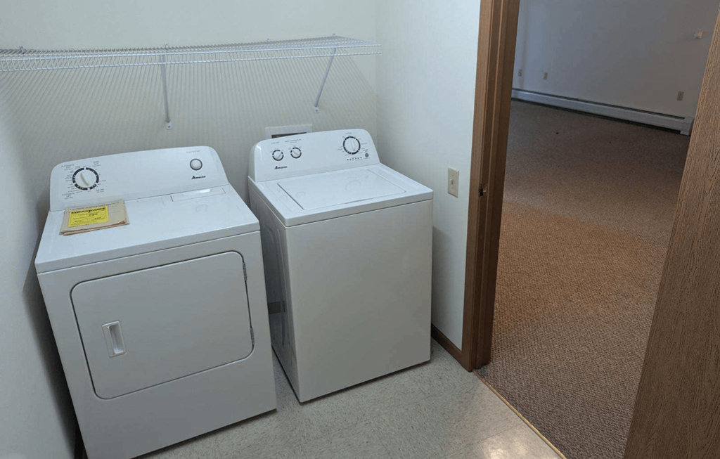 three washing machines in a room next to a door
