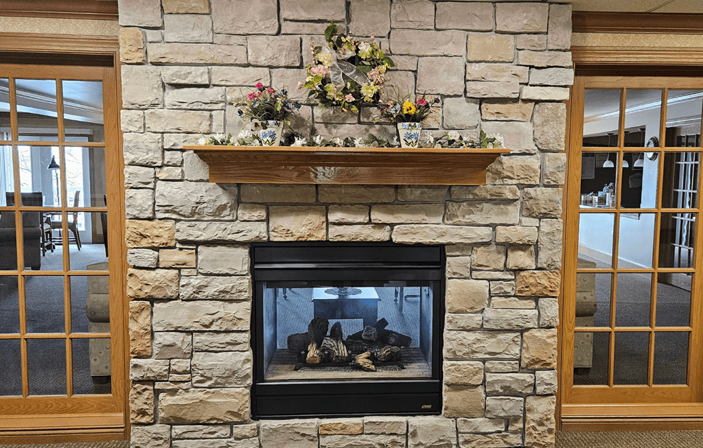 a large stone fireplace in a living room with a shelf above it