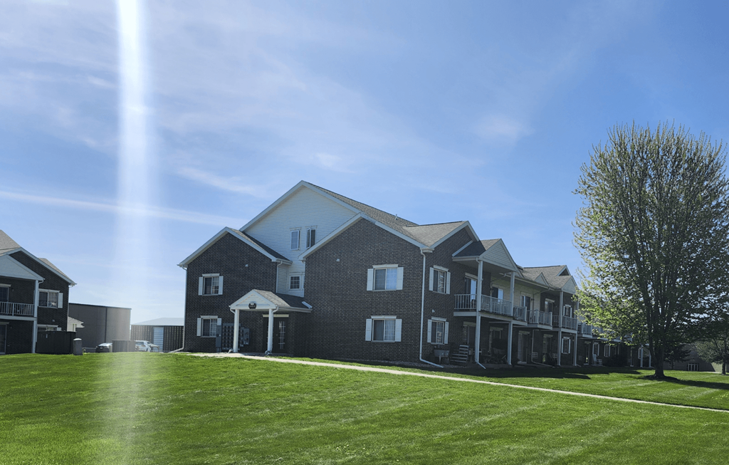 A large house with a green lawn in front.