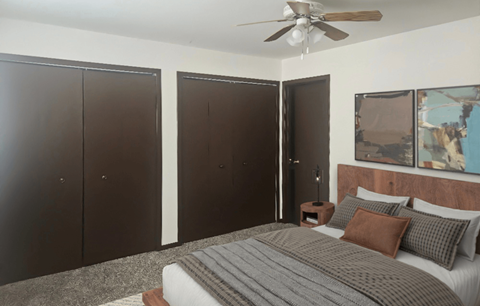 A bedroom with a bed, pillows, and a ceiling fan.