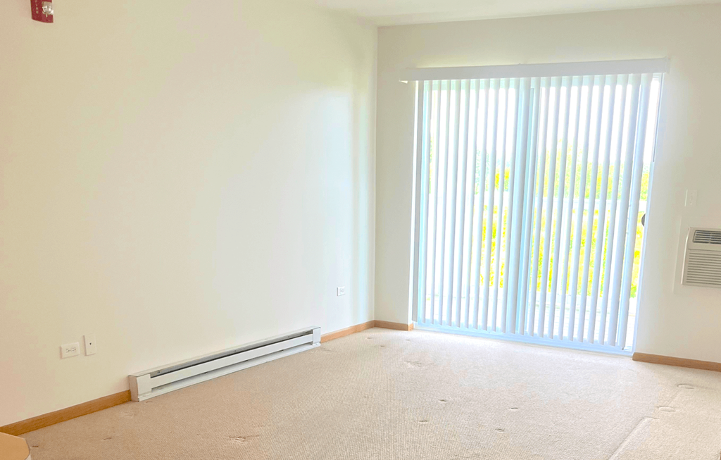 a bedroom with a large window and white walls