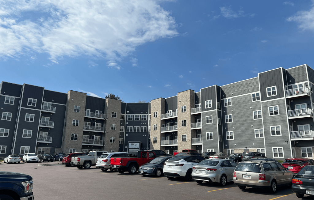 a large apartment building with a parking lot in front of it