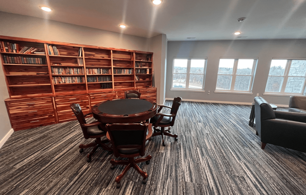 a conference room with a table and chairs and a bookshelf