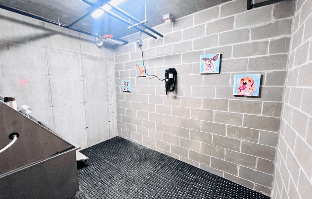a white tiled bathroom with a sink and a urinal