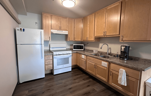 A kitchen with wooden cabinets and a white refrigerator.