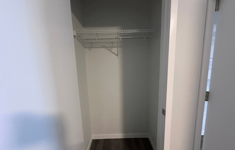 Empty white hallway with a shelf on the wall.