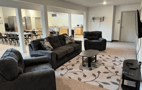 A living room with a grey couch and a black armchair.