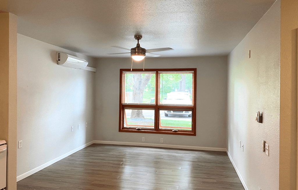 A room with a window and a ceiling fan.