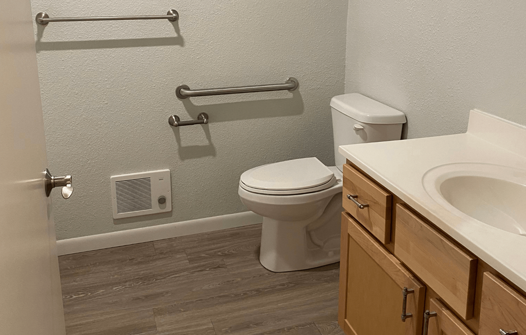 A white toilet sits next to a sink in a bathroom.