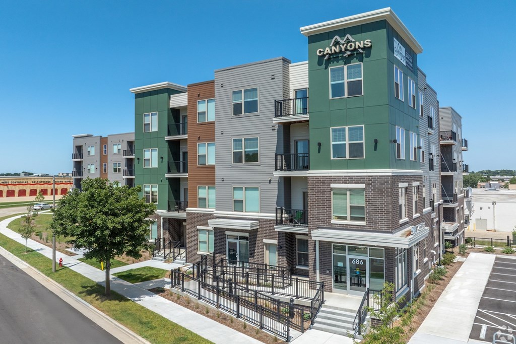 A modern apartment complex named Canyons is shown in the image.