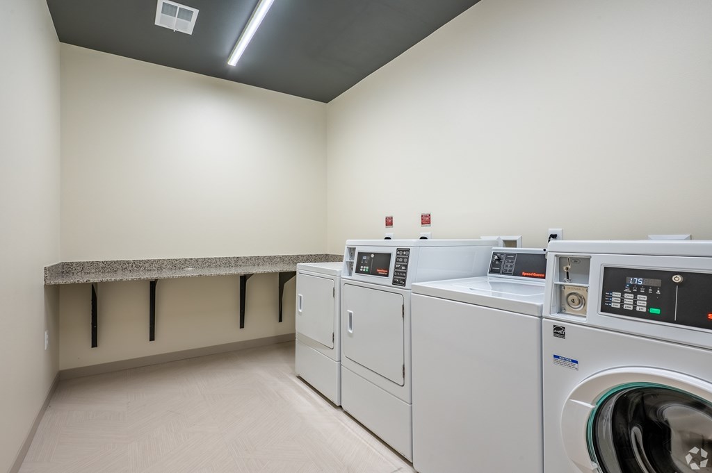 A row of washing machines in a laundry room.