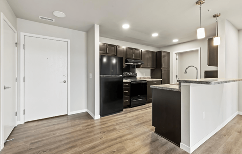 A kitchen with a white counter and black cabinets.