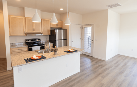 a kitchen with a large island and a stainless steel refrigerator