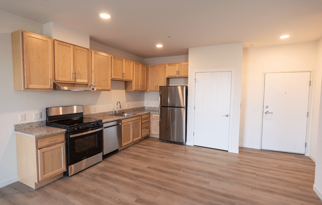 an empty kitchen with wooden cabinets and stainless steel appliances