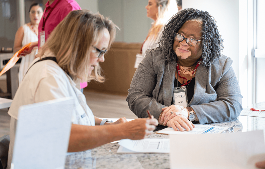 two people sitting at a table working on papers
