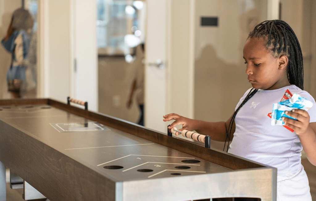 a little girl playing with a toy at a counter