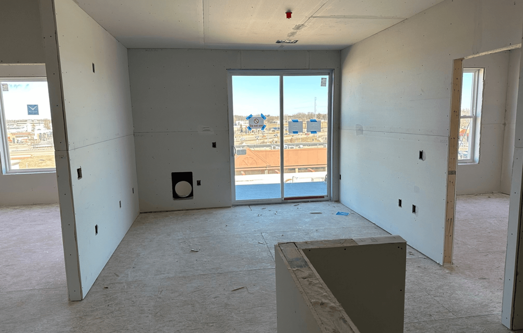 an empty living room with a door to a balcony