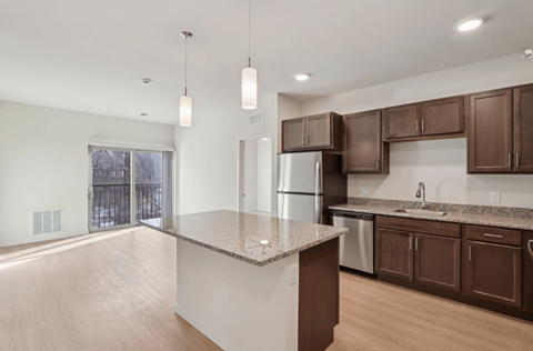 A kitchen with brown cabinets and a granite countertop.