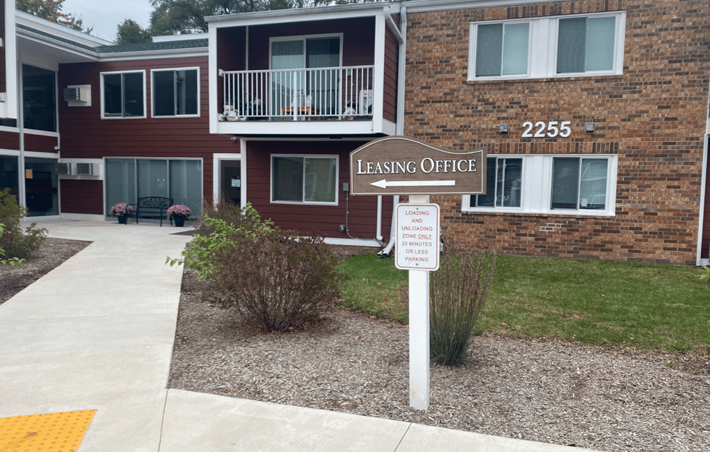 A leasing office is located in the front of a brick building.