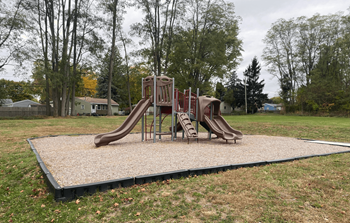 A playground with a slide and a swing set.