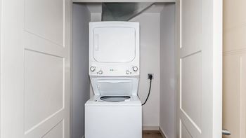 A white washing machine is in a small alcove.