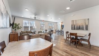 A dining room with a large table and chairs.