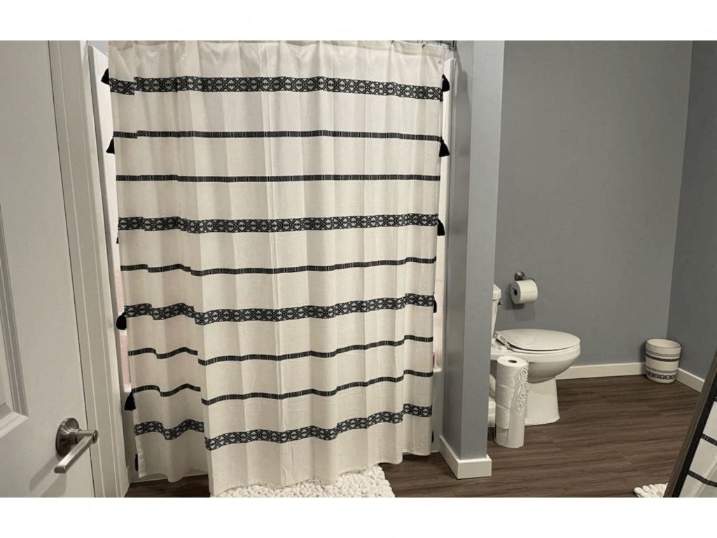 a bathroom with a toilet and a shower curtain