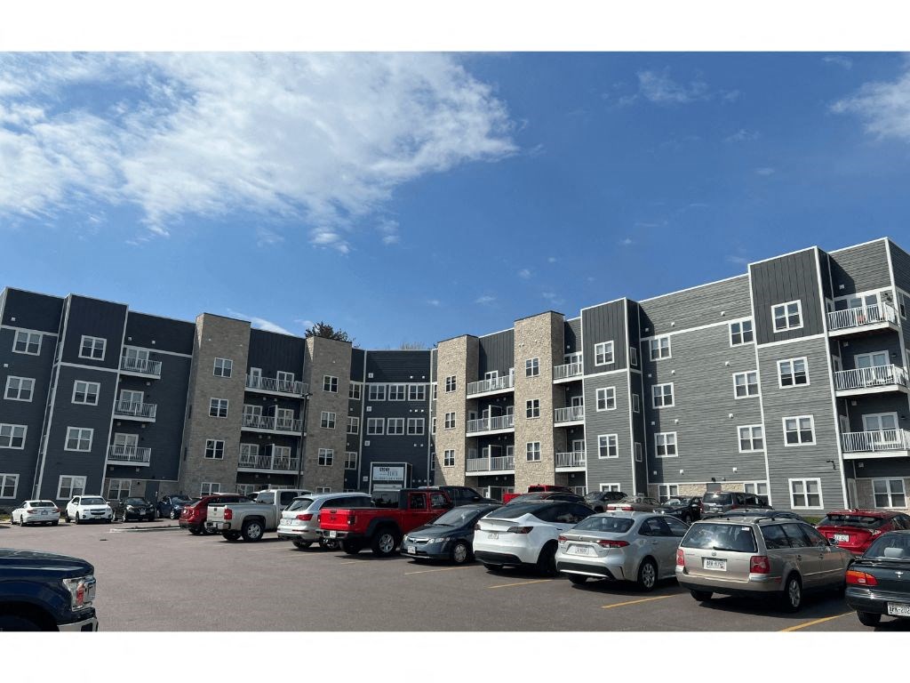 a large apartment building with a parking lot in front of it